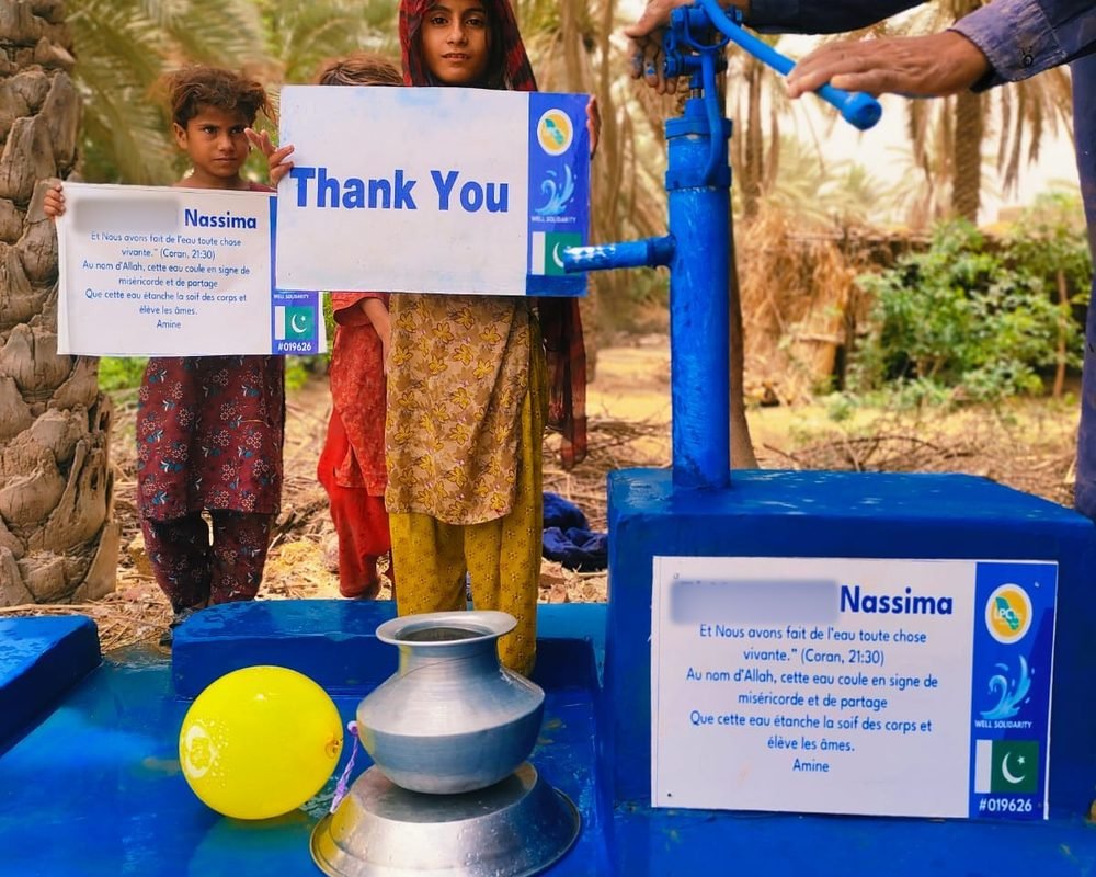 Puits bleu terminé au Pakistan, avec sa pancarte et les enfants du village
